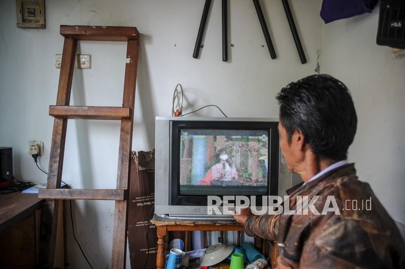 Seorang petugas keamanan menonton siaran TV analog di Cinunuk Kabupaten Bandung Jawa Barat Kamis 1722022 Kementerian Komunikasi dan Informatika akan menghentikan siaran TV analog tahap pertama pada 30 April 2022 mendatang di 12 daerah di Jawa Barat