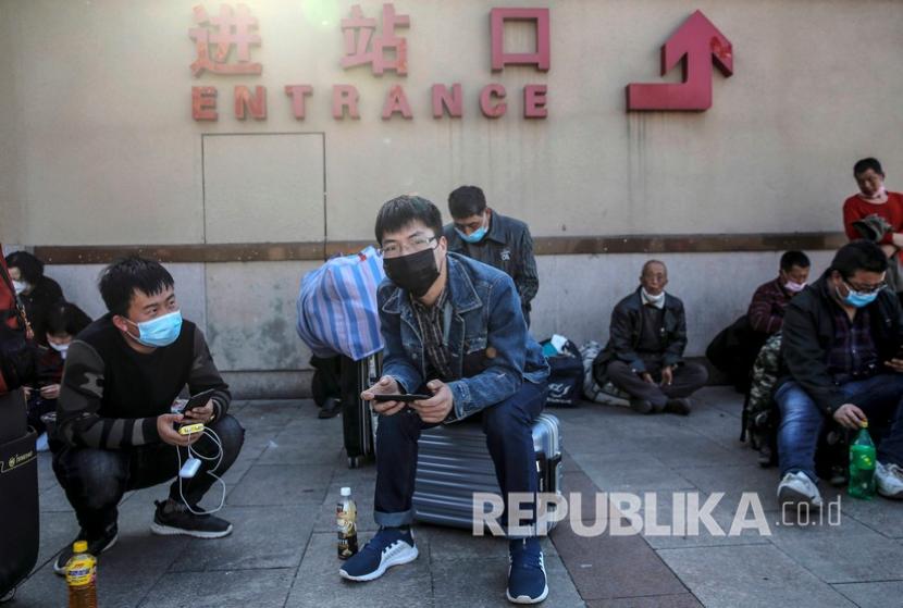 Penumpang dengan mengenakan masker menunggu di luar stasiun kereta api Beijing China Penyedia jasa layanan kereta api di China terpukul oleh lonjakan kasus Omicron Ilustrasi