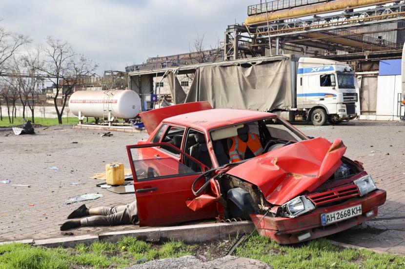 Mayat seorang warga sipil tergeletak di sebelah mobil yang rusak di dekat Pabrik Metalurgi Illich Iron Steel Works perusahaan metalurgi terbesar kedua di Ukraina di daerah yang dikendalikan oleh pasukan separatis yang didukung Rusia di Mariupol Ukraina Sabtu 16 April 2022