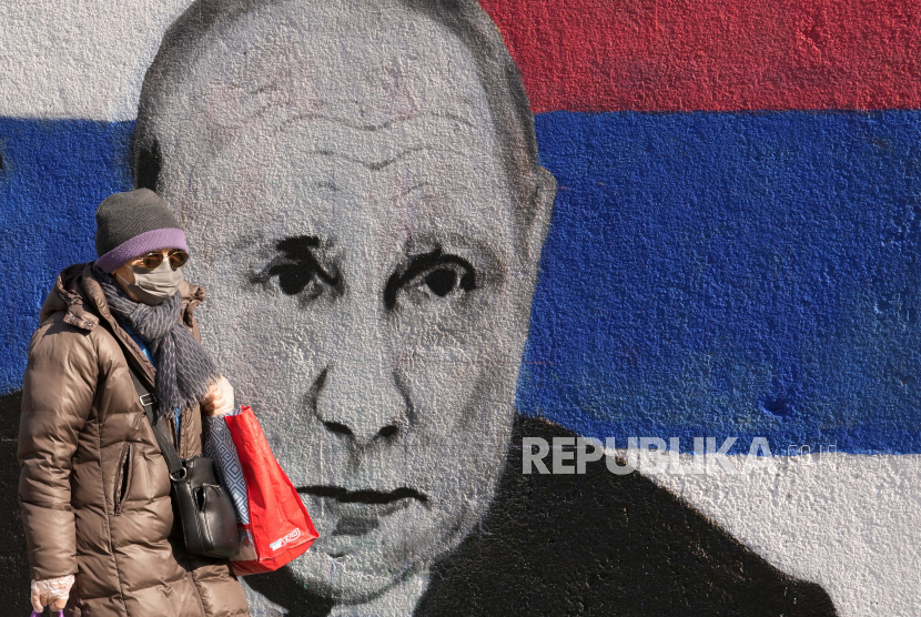 Seorang wanita melewati mural yang menggambarkan Presiden Rusia Vladimir Putin Jerman mencatat adanya kenaikan jumlah warga negara Rusia yang mengajukan suaka ke negara itu Ilustrasi