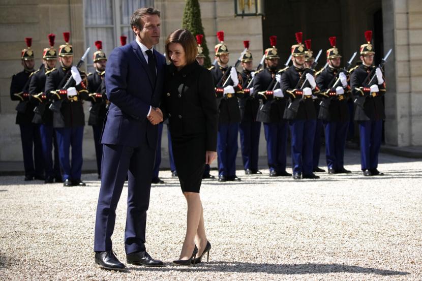 Presiden Prancis Emmanuel Macron kiri menyambut Presiden Moldova Maia Sandu sebelum pembicaraan mereka di Istana Elysee Kamis 19 Mei 2022 di Paris Macron menyatakan keprihatinan tentang risiko konflik di Ukraina menyebar ke negara negara tetangga termasuk Moldova