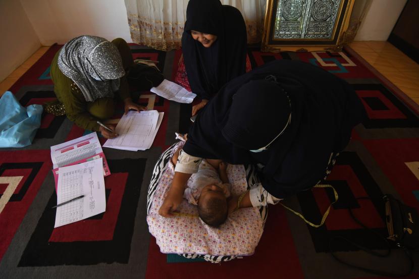Kader posyandu mengukur lingkar kepala bayi untuk mendeteksi dini risiko kekerdilan stunting di Kelurahan Layana di Palu Sulawesi Tengah