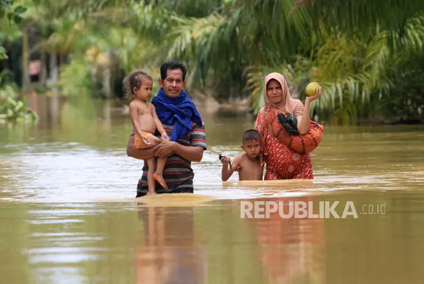 Dua warga bersama anaknya berusaha melintasi banjir Foto ilustrasi
