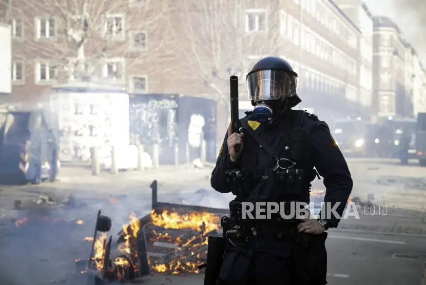 File Petugas polisi Denmark berjaga di dekat api yang dinyalakan oleh orang orang yang melakukan protes setelah seorang provokator sayap kanan melemparkan Alquran ke udara