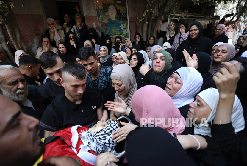 Warga Palestina membawa jenazah Fris Zaid yang berusia 14 tahun saat dilakukan pemakaman di kota Qalqilya di Tepi Barat 2772023