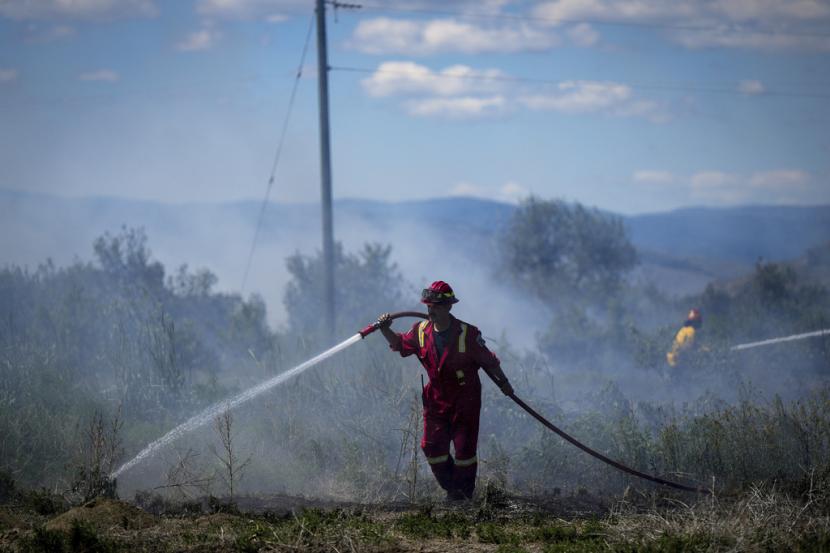 Seorang petugas pemadam kebakaran mengarahkan air ke api rumput di Kanada ilustrasi Kementerian Luar Negeri memastikan tak ada WNI yang menjadi korban kebakaran hutan di Kanada