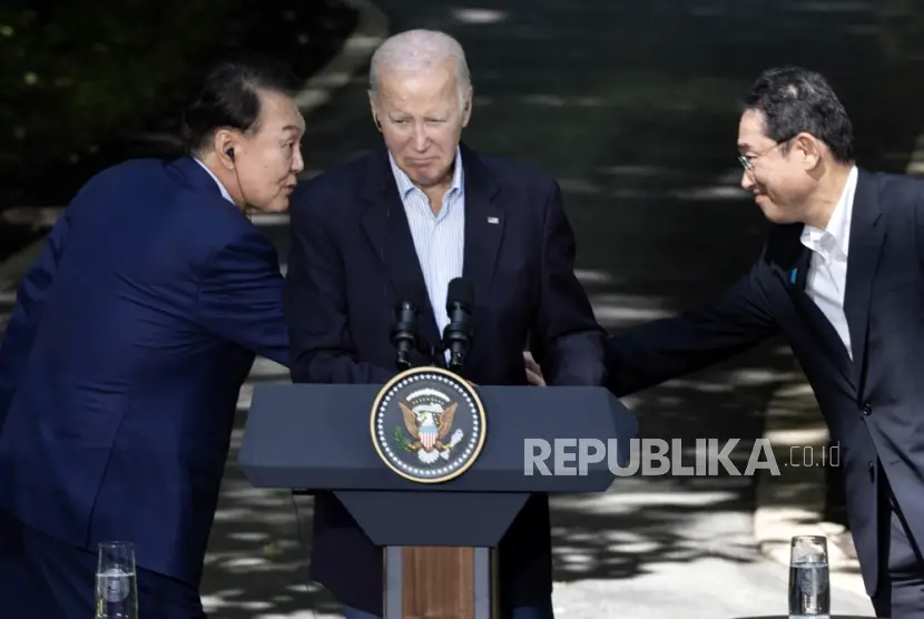 Presiden Korsel Yoon Suk Yeol kiri berjabat tangan dengan PM Jepang Fumio Kishida kanan di depan Presiden AS Joe Biden selama konferensi pers di Camp David Maryland AS 18 Agustus 2023