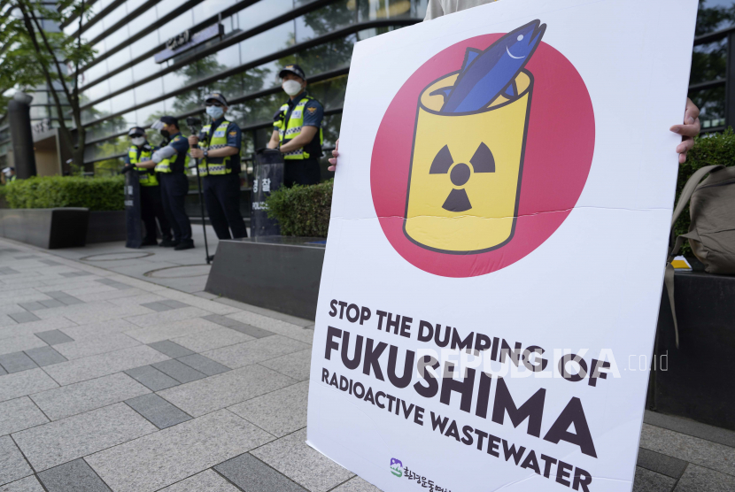 Seorang anggota kelompok sipil memegang spanduk menuntut penarikan keputusan pemerintah Jepang untuk melepaskan air radioaktif yang diolah dari pembangkit listrik tenaga nuklir Fukushima Daiichi yang rusak akibat gempa dan tsunami 2011 di dekat sebuah gedung yang menampung Kedutaan Besar Jepang di Seoul Korea Selatan Rabu 2 Juni 2021