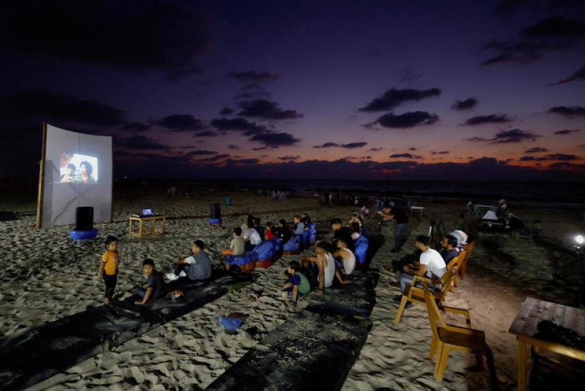 Warga Gaza Palestina melihat layar tancap di pantai merindukan kembali bioskop yang 30 tahun lebih tutup