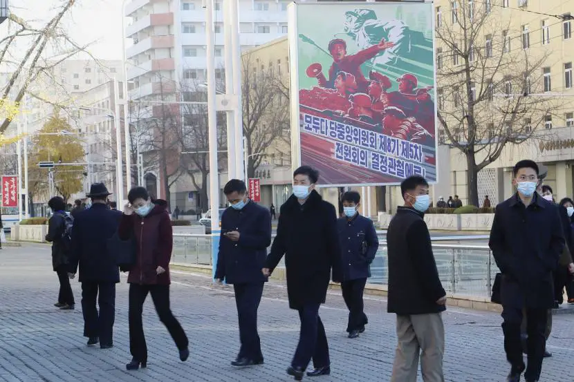 Warga berjalan dengan mengenakan masker di jalan sepanjang Stasiun Kereta Api Pyongyang di Distrik Pusat Pyongyang Korea Utara Jumat 4112022