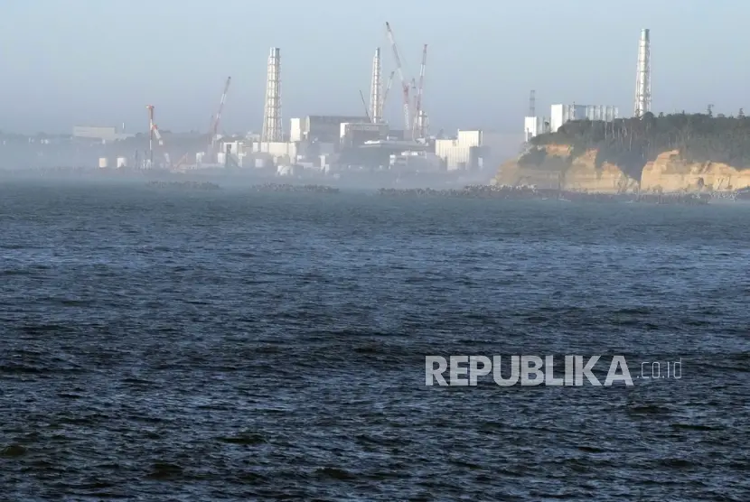 Pembangkit listrik tenaga nuklir Fukushima Daiichi rusak akibat gempa bumi dan tsunami besar pada 11 Maret 2011 terlihat dari dekat pelabuhan perikanan Ukedo di kota Namie timur laut Jepang Kamis 2482023