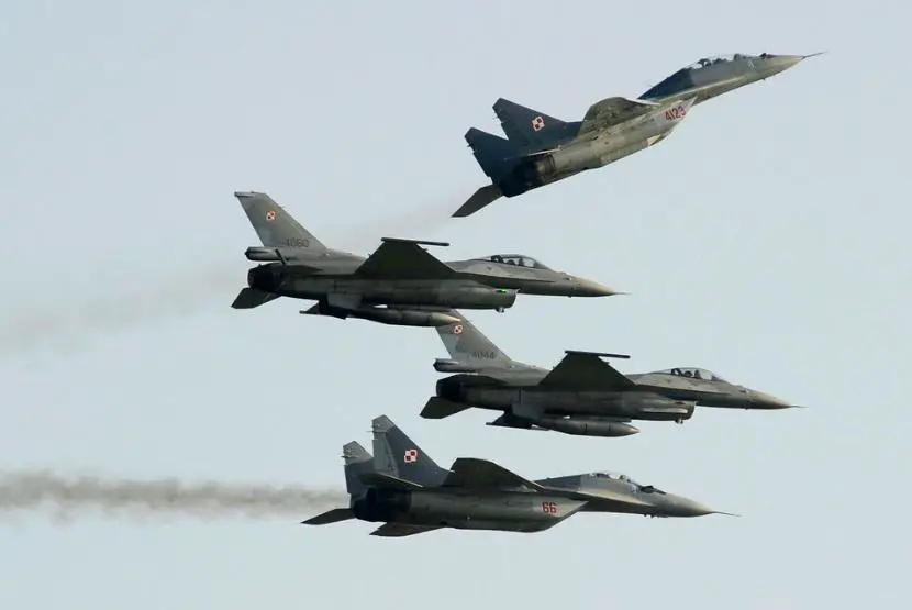 Angkatan Udara Polandia menerbangkan pesawat buatan Rusia MiG 29 atas dan jet tempur F 16 di Radom Polandia 27 Agustus 2022