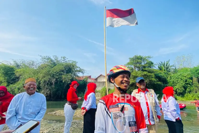 Anggota Komunitas Peduli Ciliwung KPC yang juga River Defender Suparno Jumar turut membersihkan sampah di Sungai Ciliwung usai upacara pengibaran bendera Kamis 1782023